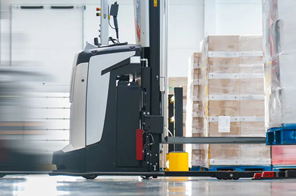 Un AGV transporte une palette dans un entrepôt pour la manutention automatisée des marchandises.