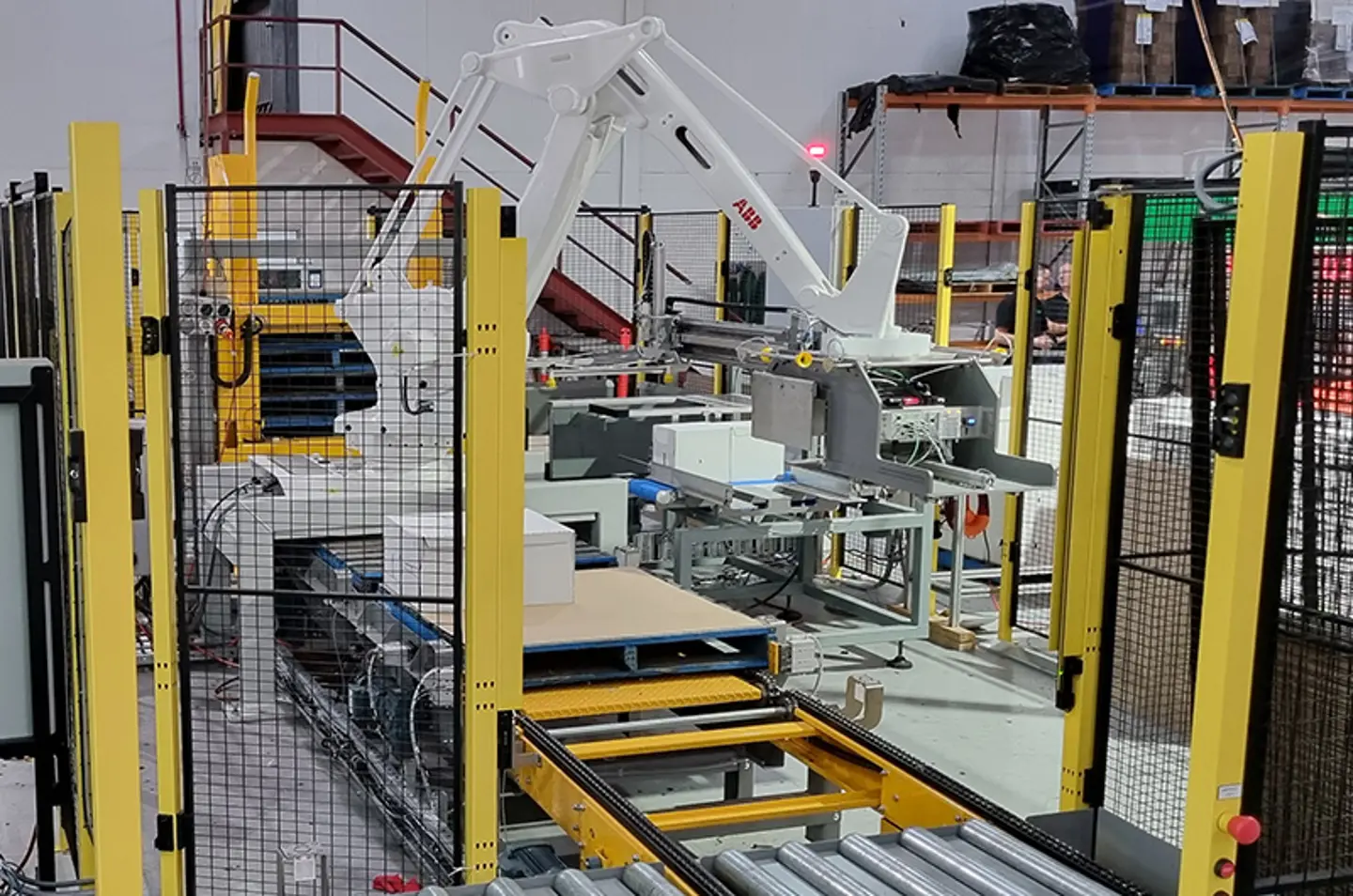 Palettiseur robotisé empilant de grands sacs avec dispositifs de protection des machines pour la sécurité des opérateurs.